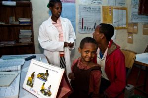 A young boy and his father visit a community health worker in Amhara Region, Ethiopia