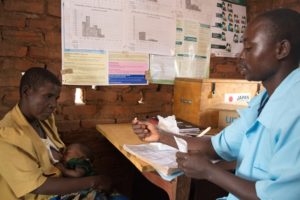 Malawian frontline health worker Petro Kangulu explains to a mother how she can give prescribed medication to her child.